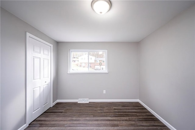 unfurnished bedroom featuring dark hardwood / wood-style floors and a closet