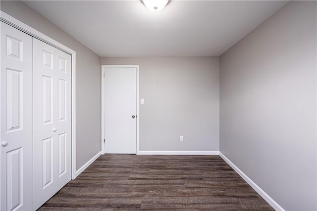 unfurnished bedroom featuring dark hardwood / wood-style flooring and a closet