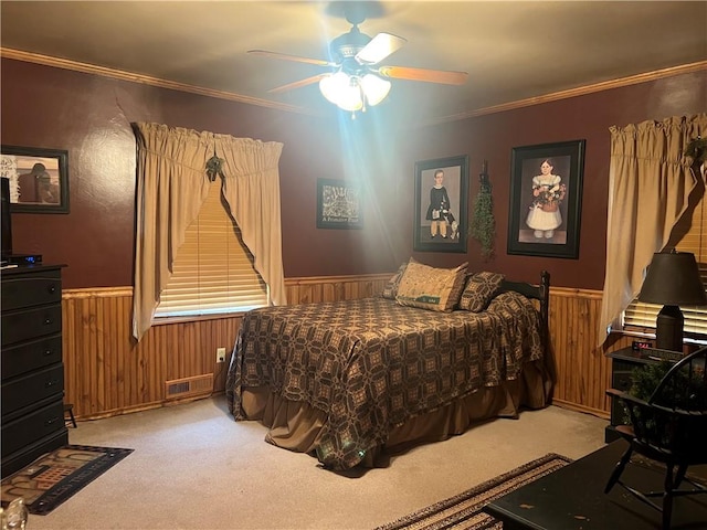 carpeted bedroom with crown molding and ceiling fan