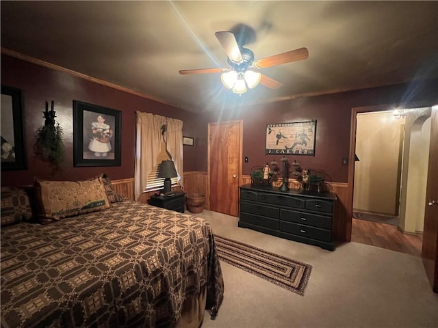 bedroom featuring ceiling fan, carpet floors, and ornamental molding