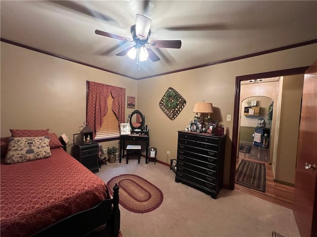 carpeted bedroom featuring ceiling fan and crown molding