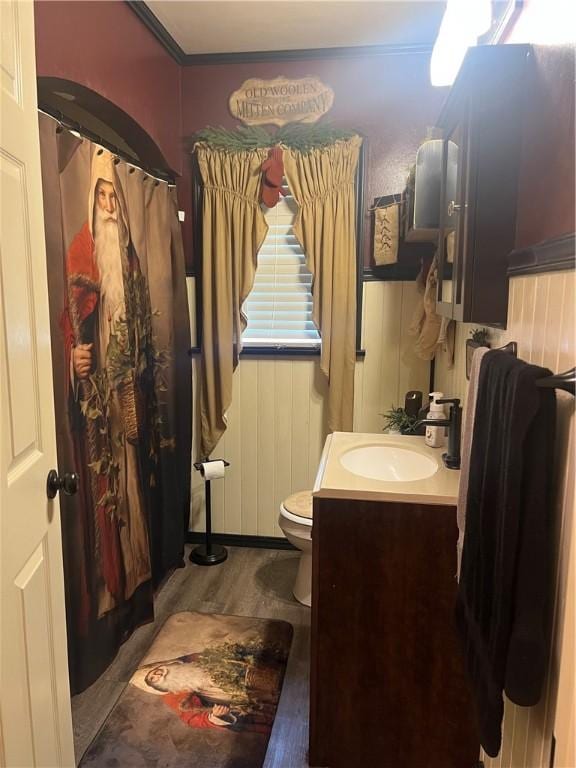 bathroom with hardwood / wood-style flooring, vanity, toilet, and wooden walls