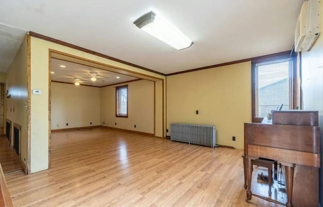 interior space with radiator, an AC wall unit, crown molding, ceiling fan, and light hardwood / wood-style floors