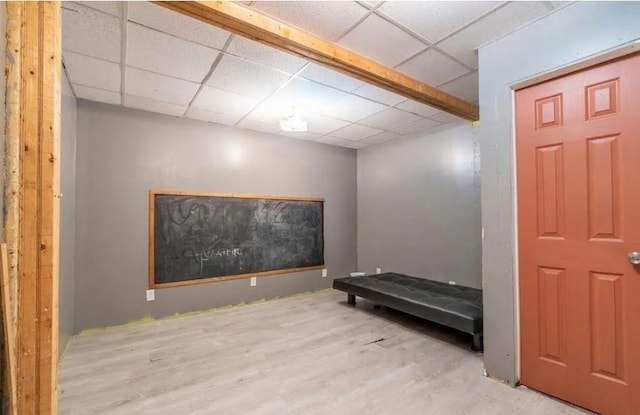 interior space with a paneled ceiling and light hardwood / wood-style flooring