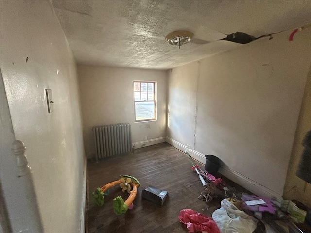 spare room featuring radiator heating unit and dark hardwood / wood-style floors