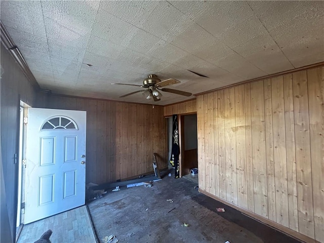 interior space with ceiling fan and wood walls