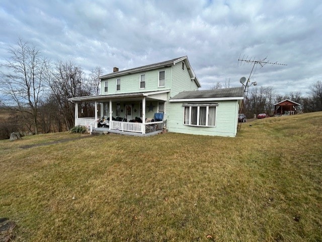 rear view of property with a lawn and a porch