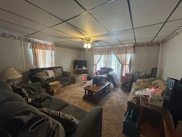 carpeted living room featuring ceiling fan, a drop ceiling, and a wealth of natural light