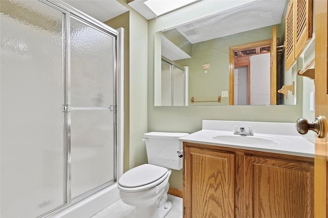 bathroom with tile patterned floors, vanity, toilet, and a shower with door