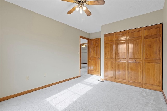 unfurnished bedroom featuring light carpet, a closet, and ceiling fan