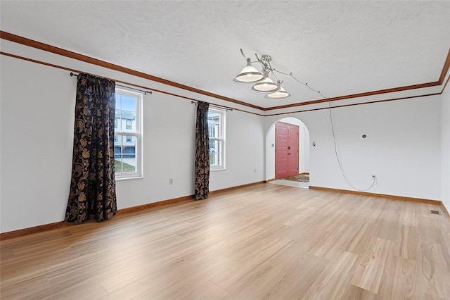 unfurnished living room featuring a textured ceiling, light wood-type flooring, and crown molding