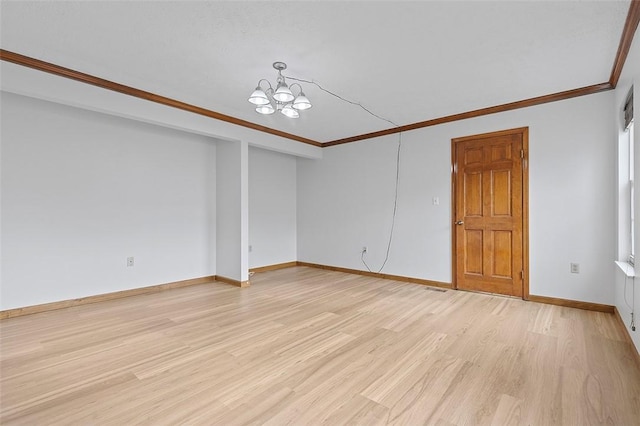 spare room featuring light hardwood / wood-style floors, crown molding, and a chandelier