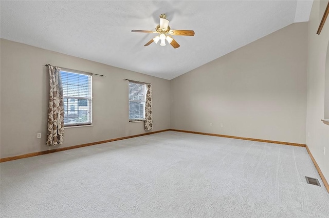 carpeted empty room featuring a textured ceiling, ceiling fan, and lofted ceiling