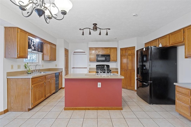 kitchen featuring sink, a center island, a chandelier, and black appliances