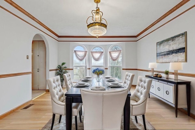 dining area featuring light hardwood / wood-style floors and crown molding