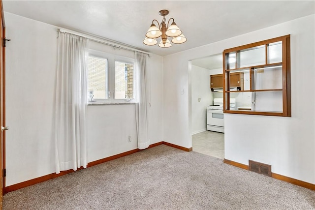 empty room featuring light carpet and an inviting chandelier