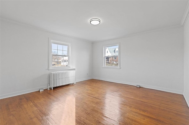 unfurnished room with radiator heating unit, crown molding, and a healthy amount of sunlight