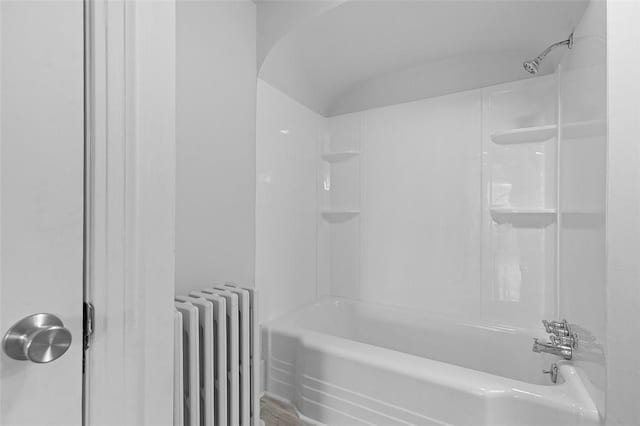 bathroom featuring shower / tub combination, radiator, and wood-type flooring