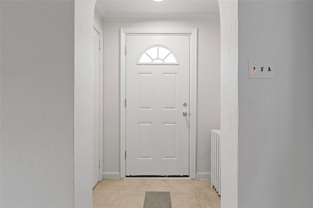 entryway with light tile patterned flooring, ornamental molding, and radiator