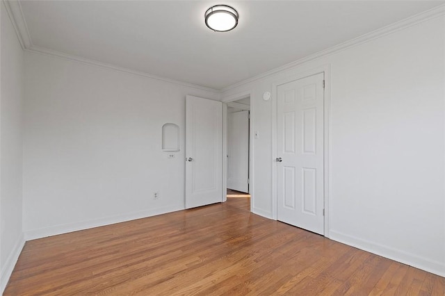 empty room with hardwood / wood-style flooring and ornamental molding