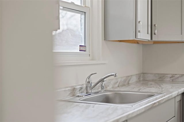 kitchen featuring light stone countertops and sink