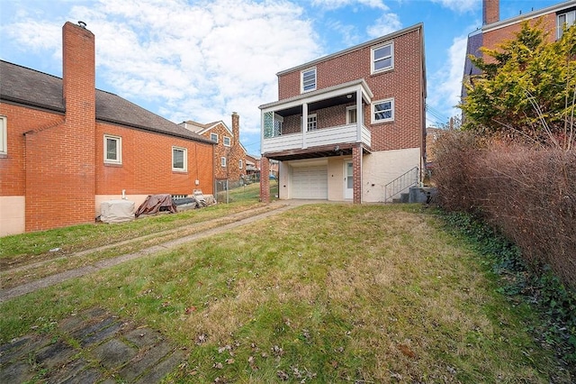 rear view of property featuring a balcony, a garage, and cooling unit