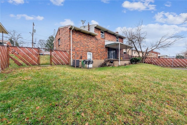 rear view of property featuring a yard and central AC unit