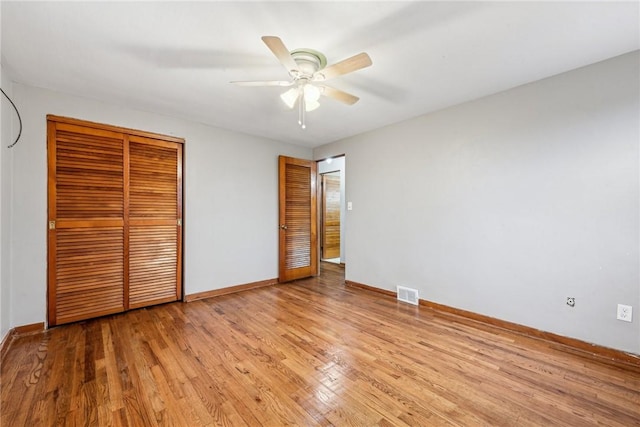 unfurnished bedroom featuring ceiling fan, light wood-type flooring, and a closet