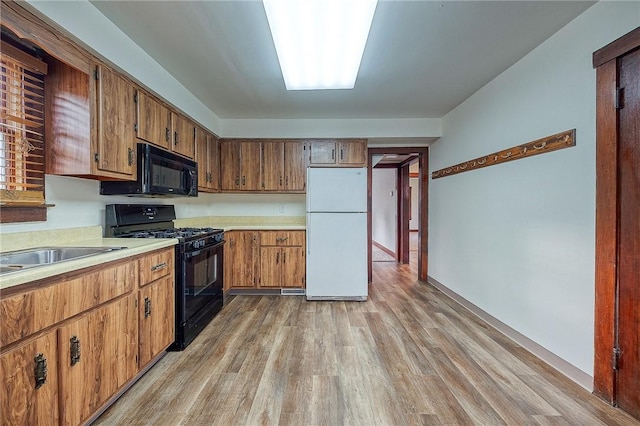 kitchen with black appliances and light hardwood / wood-style floors