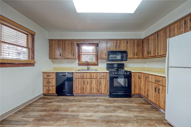 kitchen featuring light wood-type flooring, sink, and black appliances