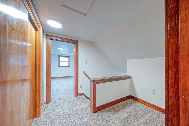 hall featuring light colored carpet and vaulted ceiling