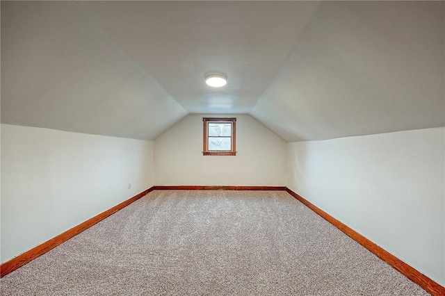 bonus room with carpet floors and vaulted ceiling