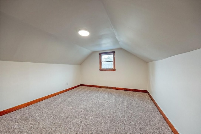 additional living space featuring carpet flooring and lofted ceiling