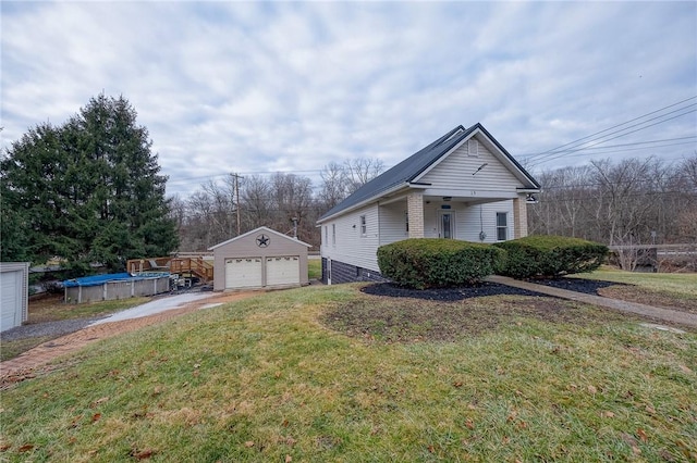 view of front of house with an outbuilding, a front lawn, a covered pool, and a garage