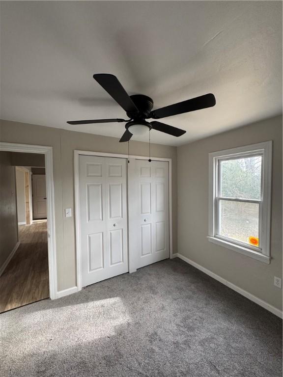 unfurnished bedroom featuring a closet, ceiling fan, and carpet