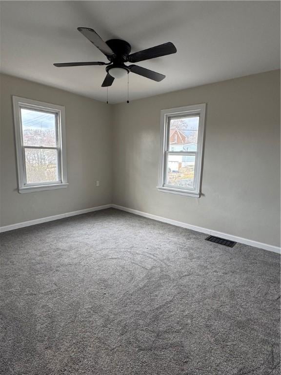 unfurnished room featuring dark colored carpet and ceiling fan