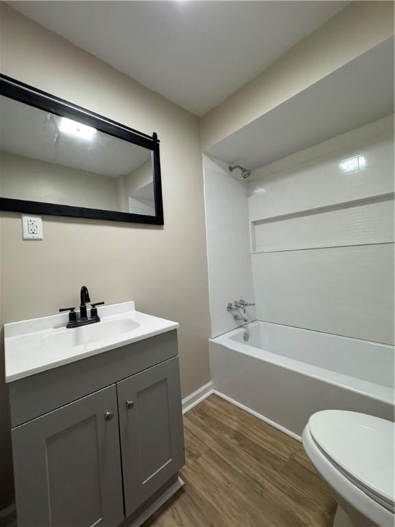 full bathroom with vanity, tub / shower combination, hardwood / wood-style floors, and toilet