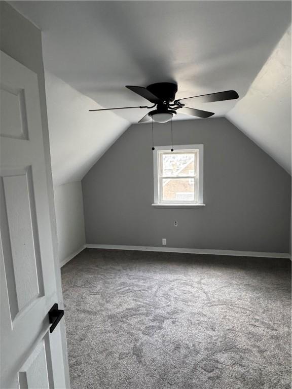 additional living space with lofted ceiling, ceiling fan, and carpet flooring