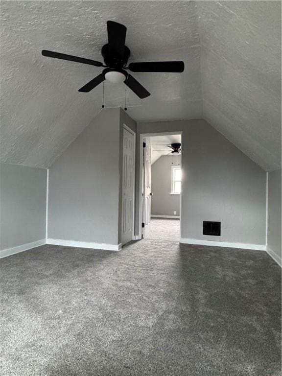 bonus room featuring vaulted ceiling, ceiling fan, carpet floors, and a textured ceiling