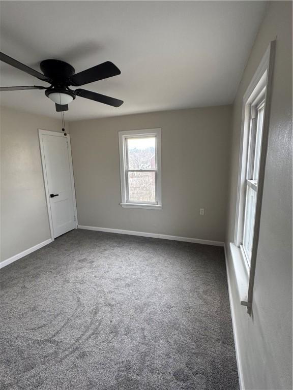 carpeted spare room with ceiling fan