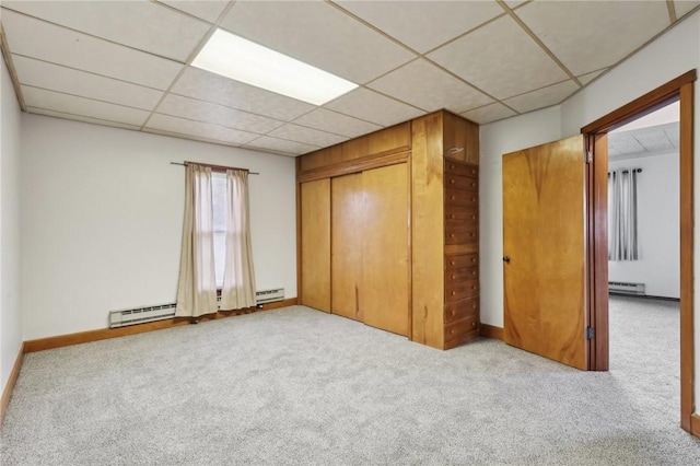 unfurnished bedroom featuring light carpet, a closet, and a baseboard radiator