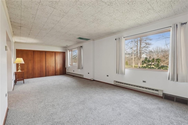 empty room featuring light colored carpet and a baseboard heating unit