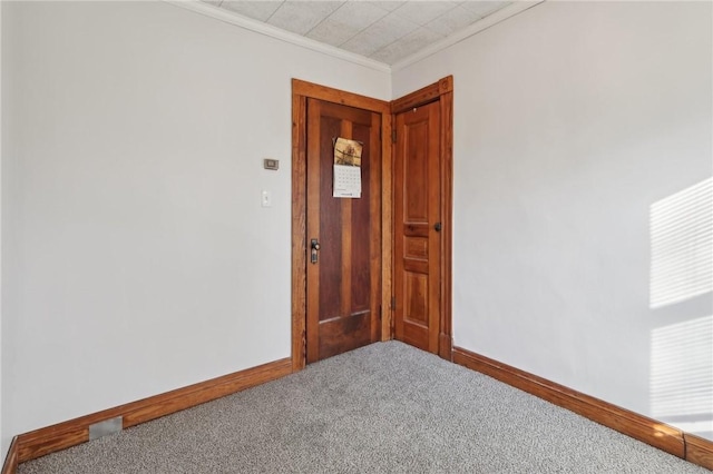 unfurnished room featuring ornamental molding and carpet floors