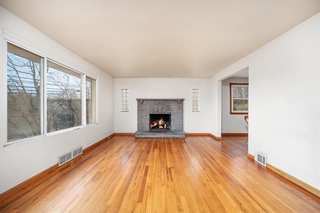 unfurnished living room featuring a fireplace and light hardwood / wood-style flooring