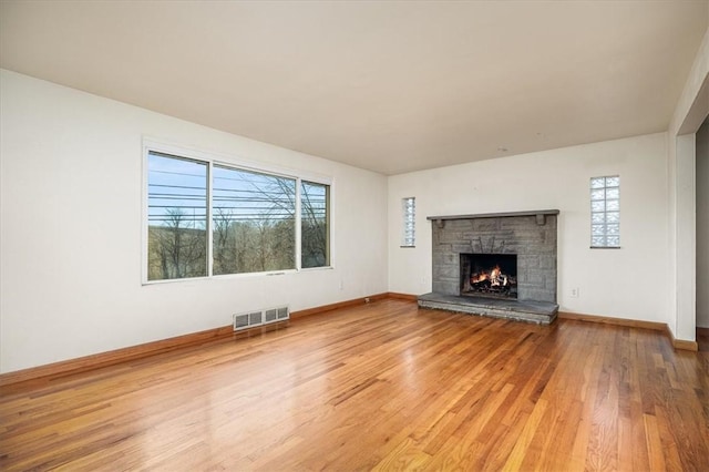 unfurnished living room featuring hardwood / wood-style flooring and a fireplace