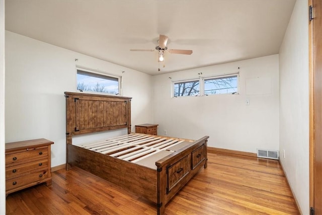 bedroom featuring ceiling fan, light wood-type flooring, and multiple windows