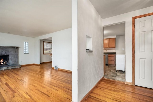 unfurnished living room with a fireplace and light hardwood / wood-style floors