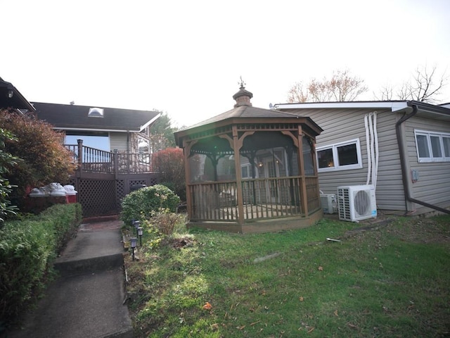 rear view of house featuring a gazebo, a wooden deck, ac unit, and a yard