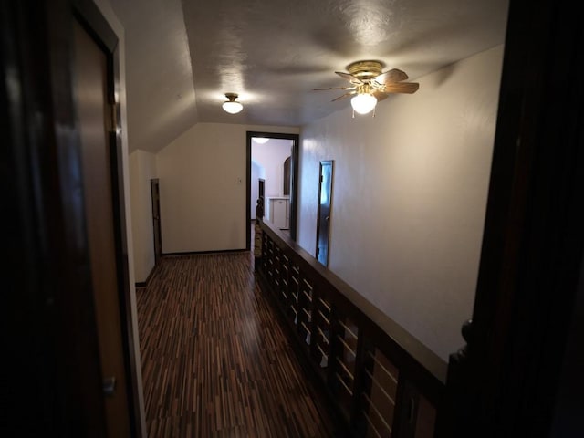 hallway with dark hardwood / wood-style flooring and lofted ceiling