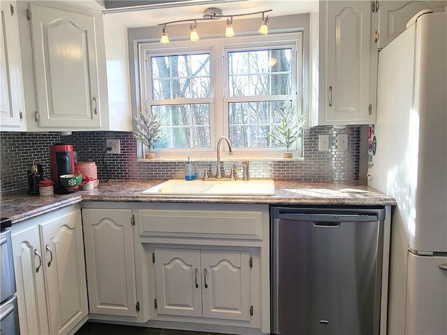 kitchen with white cabinets, stainless steel dishwasher, and white refrigerator